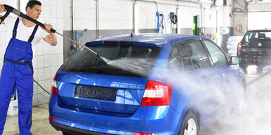 professionelle Autowsche in einer Werkstattmit Hochdruckreiniger